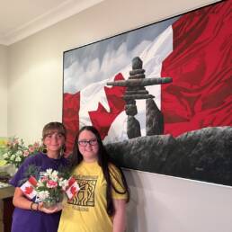 Lauren Abela (left) and Jessica Rotolo (right) holding flowers on Canada Day.