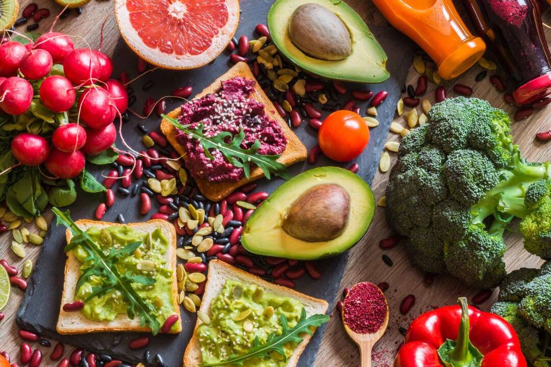 a variety of plant-based food such as avocados, grapefruit, bread, and lots of veggies. as