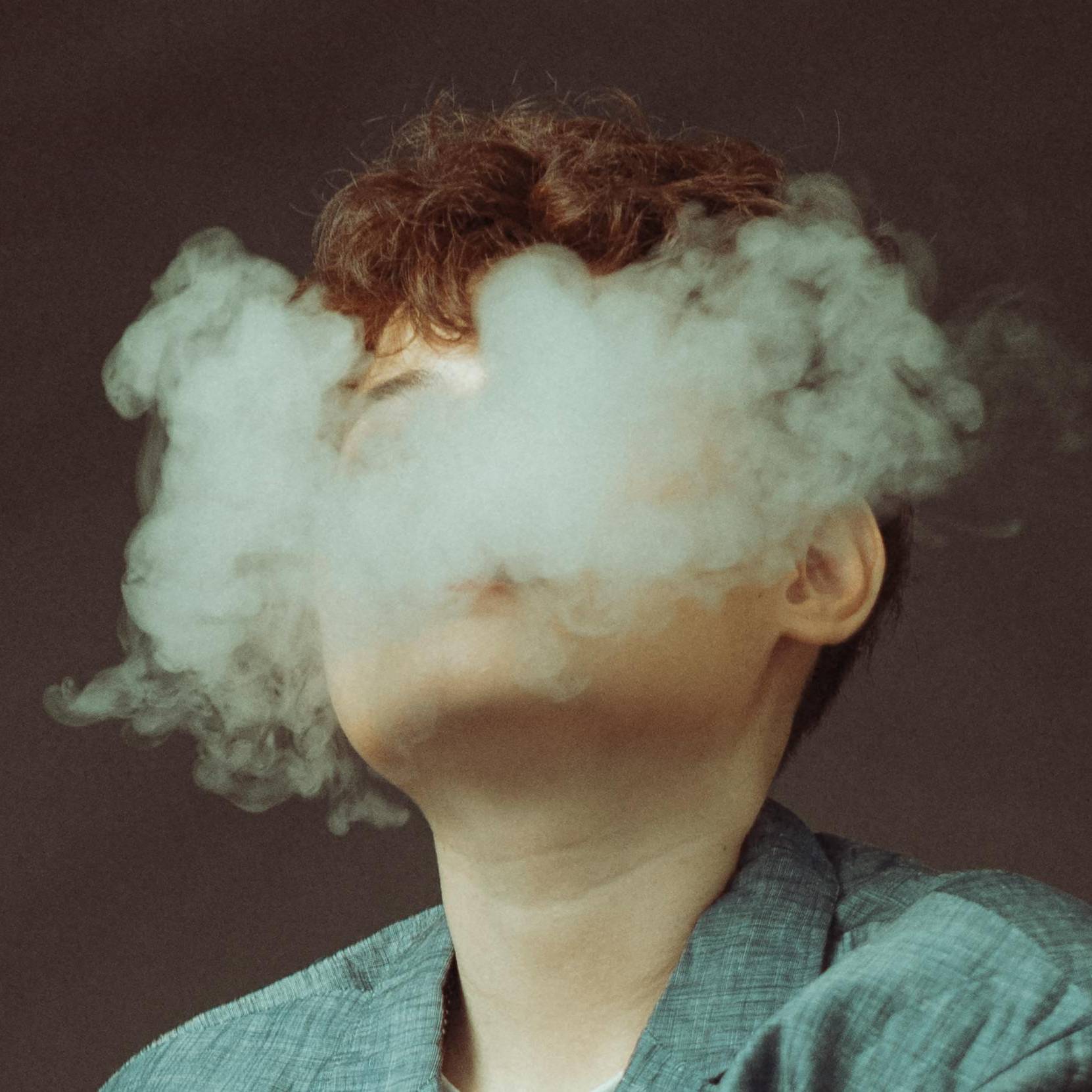 Woman Hidden Behind E-Cigarette Smoke