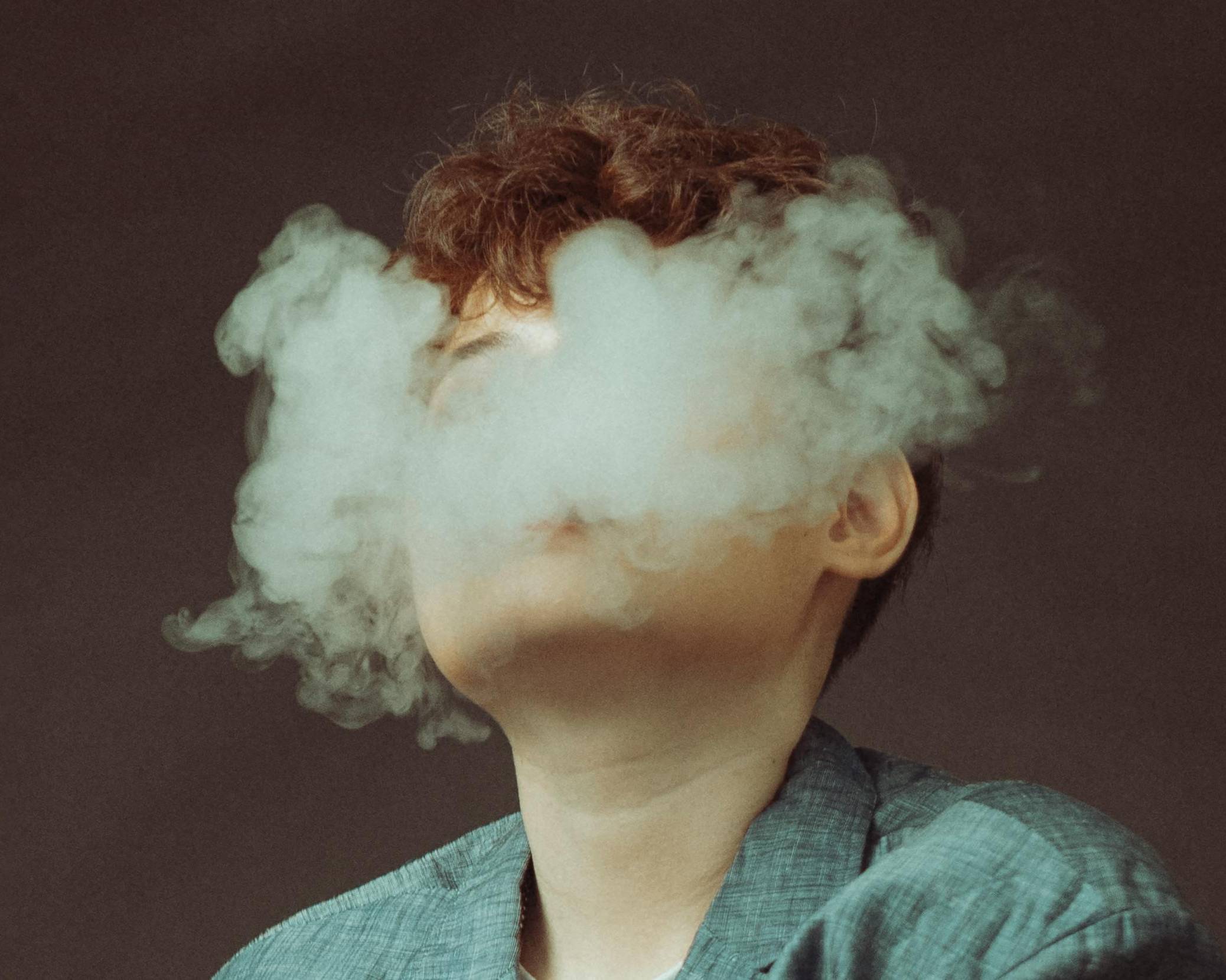Woman Hidden Behind E-Cigarette Smoke