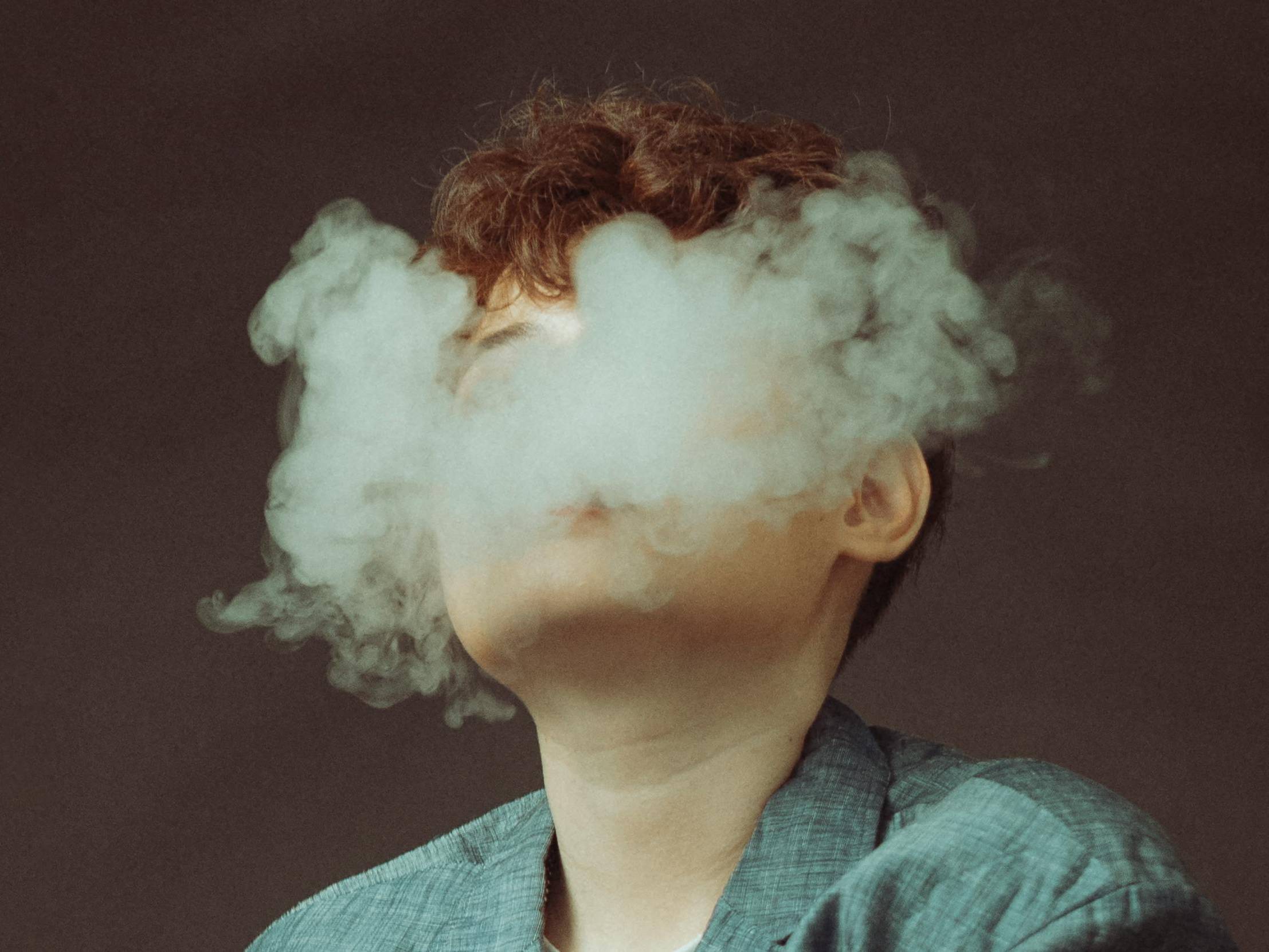 Woman Hidden Behind E-Cigarette Smoke