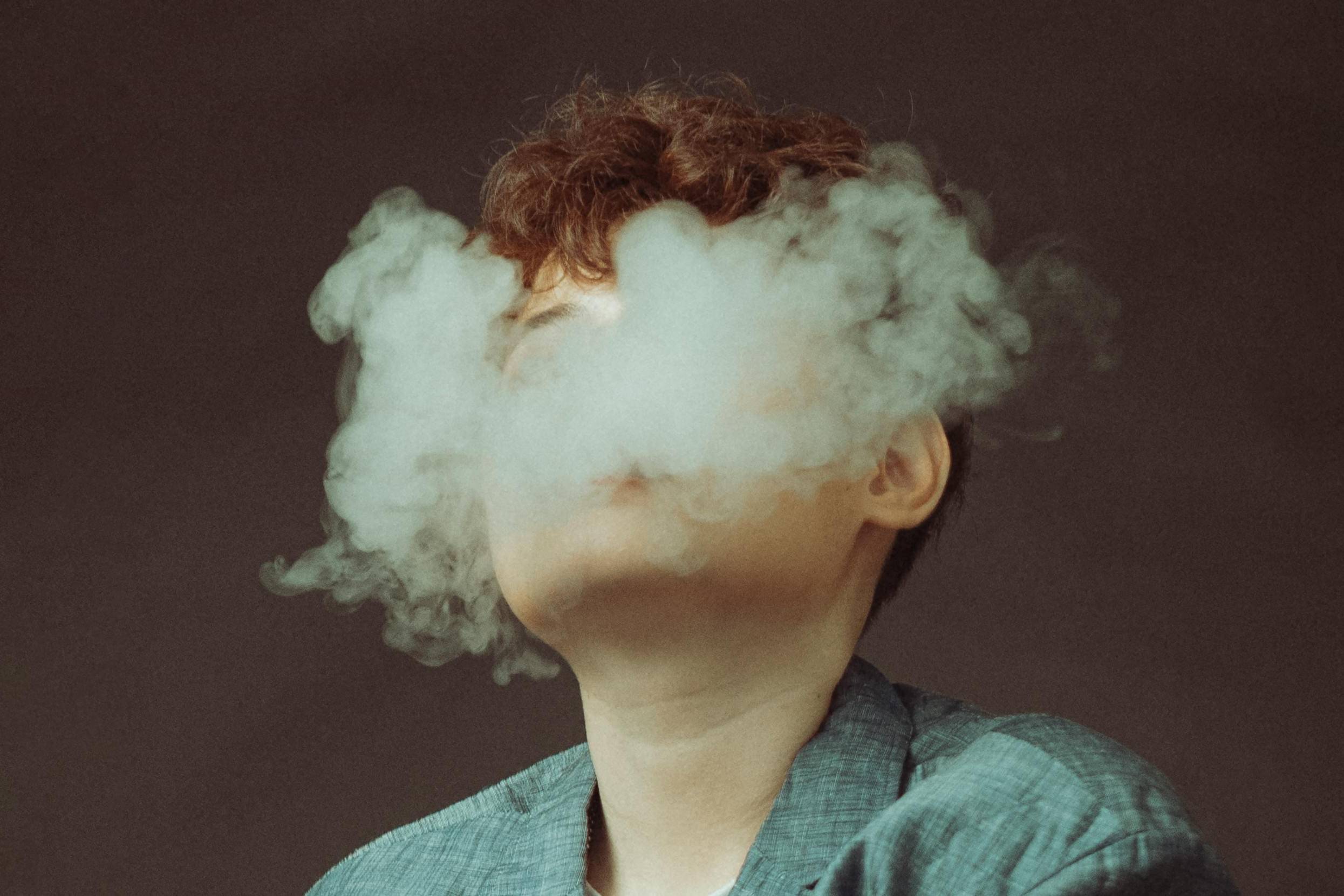 Woman Hidden Behind E-Cigarette Smoke